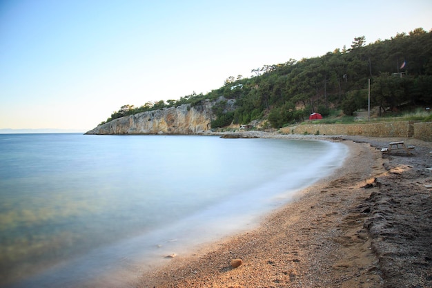 Verlassener Strand mit seidigem Meer durch Langzeitbelichtung