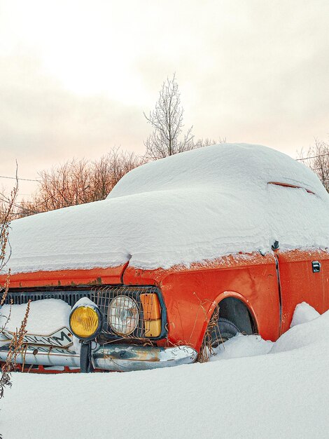 Foto verlassenes auto auf einem schneebedeckten feld