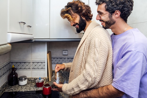 Verliebte Männer umarmen sich, während sie Kaffee zubereiten