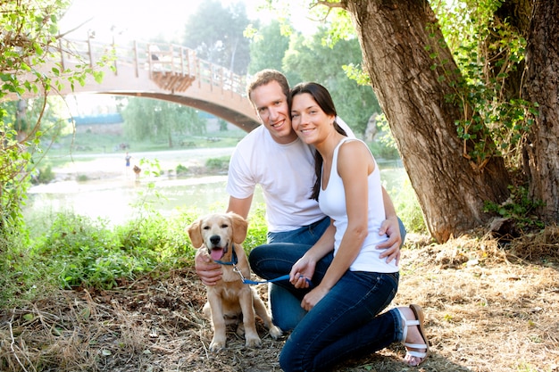 Verliebte Paare mit Hund im Fluss im Freien