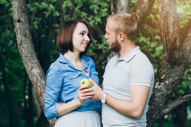 Verliebte Paare ruhen sich im Sommer im Apfelgarten aus