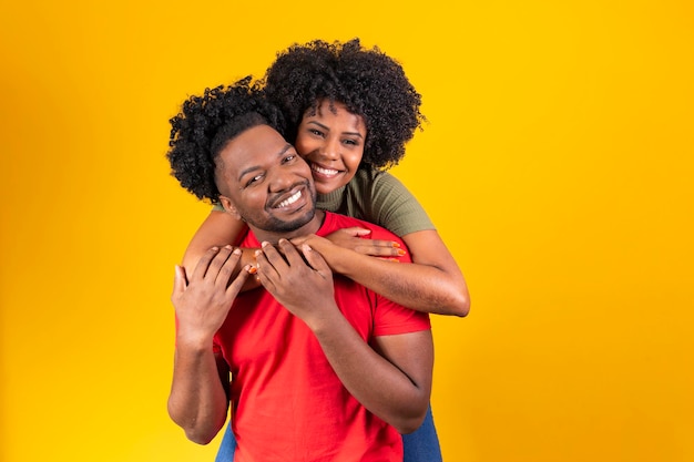 Verliebtes Afro-Paar tauscht Kuscheln und Zuneigung auf gelbem Hintergrund aus