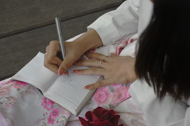 Verliebtes Mädchen schreibt einen Brief in ein Notizbuch.