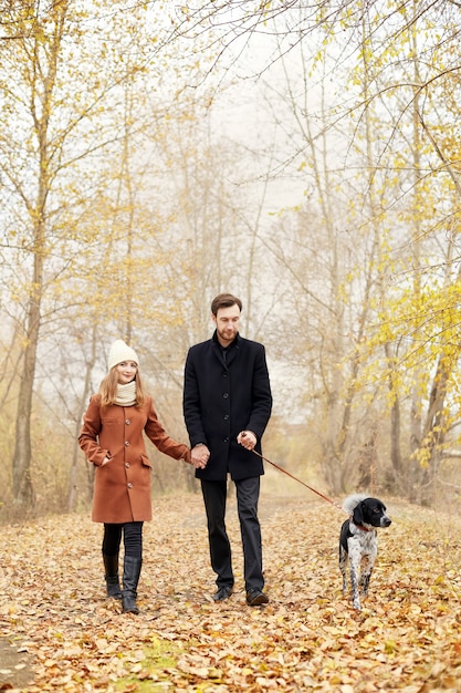 Verliebtes Paar am Valentinstag mit dem Hund im Park spazieren. Die Liebe und Zärtlichkeit zwischen einem Mann und einer Frau. Valentinstag ist ein Feiertag aller Verliebten