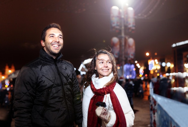 verliebtes paar am weihnachtsabend in der stadt spazieren