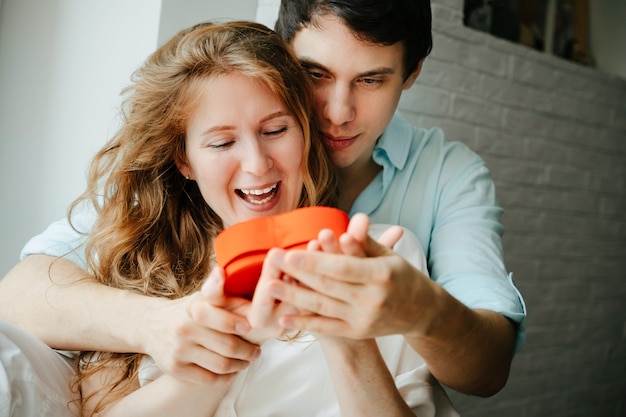 Verliebtes Paar beobachtet eine Geschenkherzbox am Valentinstag.