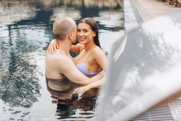 Verliebtes Paar, das zusammen im Pool schwimmt