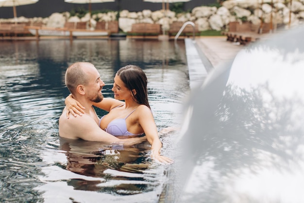 Verliebtes Paar, das zusammen im Pool schwimmt