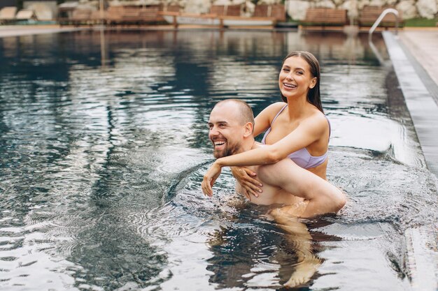 Verliebtes Paar, das zusammen im Pool schwimmt