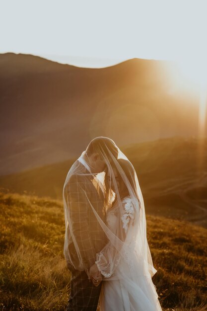 verliebtes paar, ein mann und ein mädchen in hochzeitskleidung stehen in den bergen