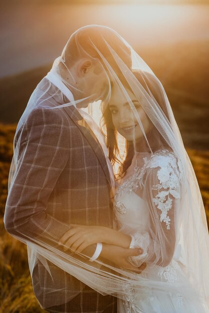 verliebtes paar, ein mann und ein mädchen in hochzeitskleidung stehen in den bergen