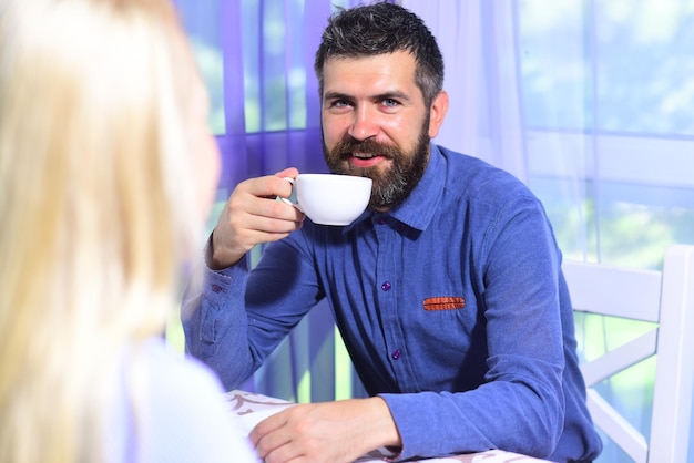 Verliebtes Paar hält Tassen Kaffee am Tisch