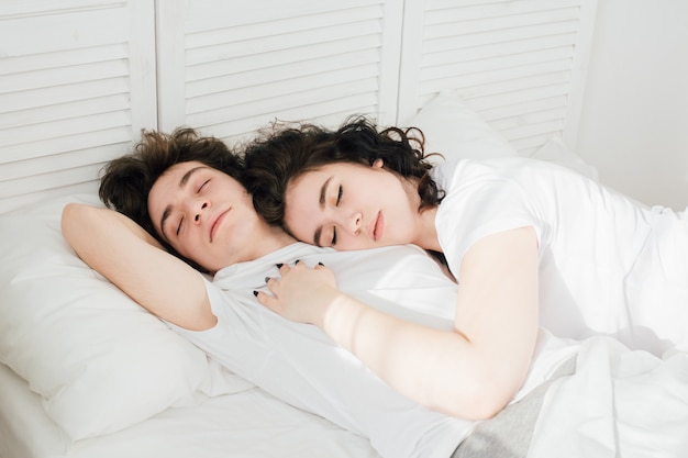 Verliebtes Paar schläft kuschelnd im Bett