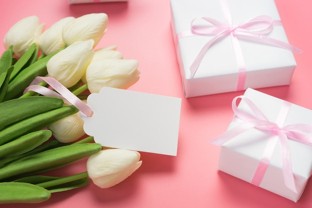 Verlieren Sie die Ansicht von weißen Tulpen und Geschenkboxen auf Rosa