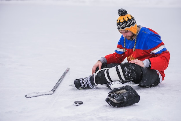 Verliererhockeyspieler, der auf dem Eis einer sitzt