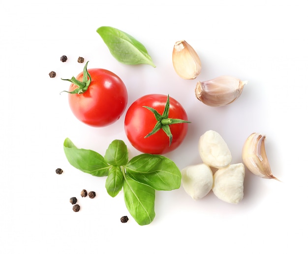 Vermelho tomate cereja, manjericão e mussarela em fundo branco