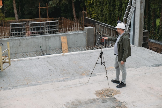 Vermessungsingenieur mit geodätischer Ausrüstung auf der Baustelle