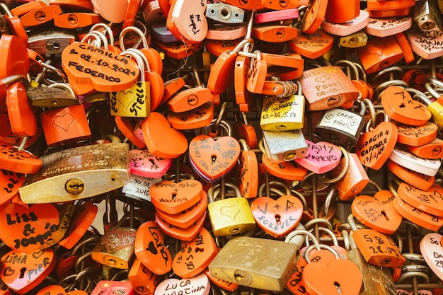 Verona, Italia, junio de 2022: el fondo de cerraduras en forma de corazón en una pared, símbolo del amor para siempre.