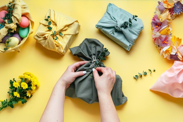 Verpacken Sie ein Geschenk in einer umweltfreundlichen, wiederverwendbaren Stoffverpackung