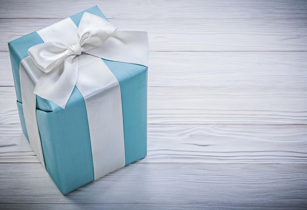 Verpackte blaue geschenkbox auf holzbrettfeierkonzept