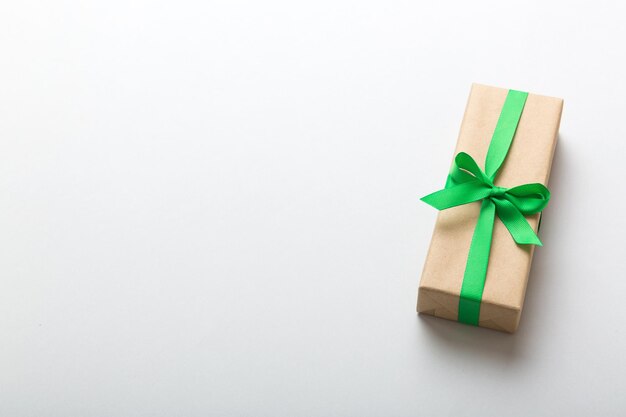 Verpacktes Weihnachts- oder anderes Feiertagshandgemachtes Geschenk in Bastelpapier mit farbigem Band Präsentkartondekoration des Geschenks auf der Tischplatte mit Kopierraum