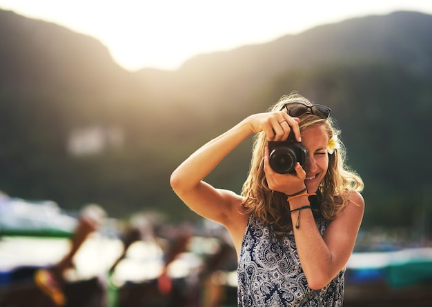 Verpassen Sie keinen Moment Porträt einer jungen Frau, die Fotos mit ihrer Kamera am Strand macht