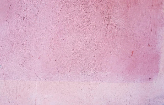 Verputzte Wand mit rosa Farbe bedeckt Die Wand eines Stadthauses Rosa Hintergrund