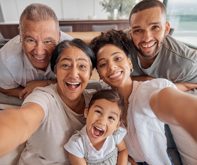 Foto verrückte selfie-porträtfamilie und großeltern, die mit liebe zu kindern auf dem wohnzimmersofa im haus lustig sind mädchen, mutter, vater und senioren, die zu hause mit komischem gesicht fotografieren