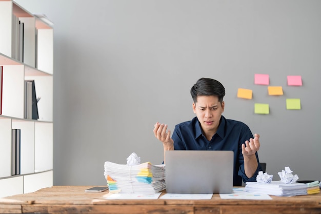 Verrückter, verrückter Angestellter sitzt am Büroarbeitsplatz mit Haftnotizen herum und schreit wütend, wütend, sauer auf Deadline und stressigen Job im Büro