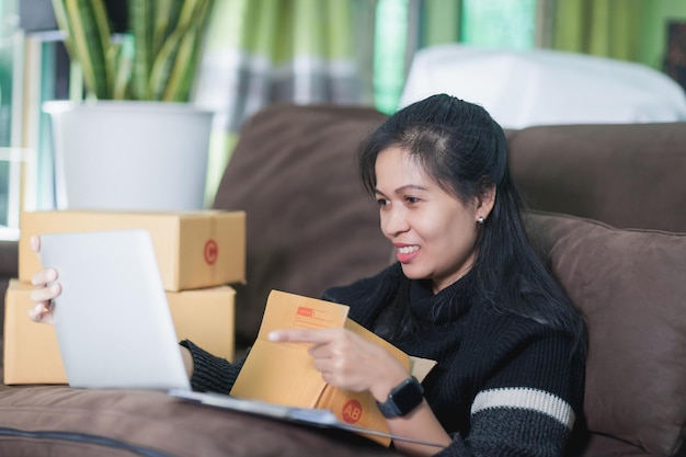 Versand online Asiatin gründet Kleinunternehmerin Die Checkliste übernimmt die Bestellung online