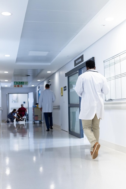 Verschiedene Ärzte und Patienten im belebten Krankenhauskorridor, mit Kopierplatz. Krankenhaus-, medizinische und Gesundheitsdienstleistungen.