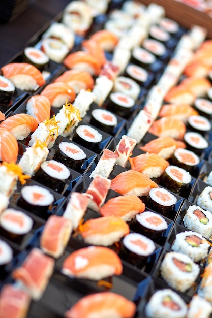 Verschiedene appetitliche Sushi mit Fisch werden in einem asiatischen Laden auf der Theke serviert