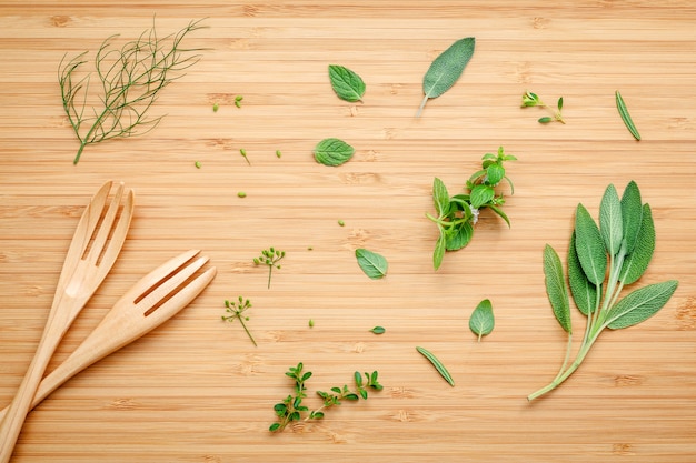 Verschiedene aromatische Kräuter und Gewürze gründen auf hölzernem Hintergrund.