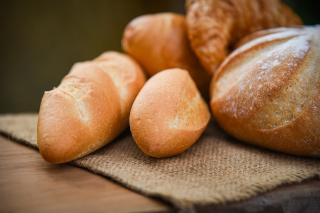 Verschiedene Arten des frischen Bäckereibrotes auf Sack in der selbst gemachten Frühstücksnahrung der rustikalen Tabelle