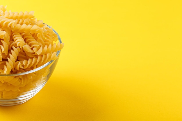 Verschiedene Arten und Formen trockener italienischer Pasta auf gelbem Hintergrund in Nahaufnahme