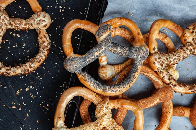 Verschiedene Arten von gebackenen Bagels mit Samen auf schwarzem Hintergrund