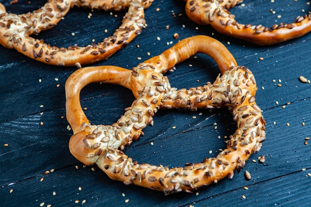 Verschiedene Arten von gebackenen Bagels mit Samen auf schwarzem Hintergrund