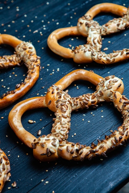 Verschiedene Arten von gebackenen Bagels mit Samen auf schwarzem Hintergrund