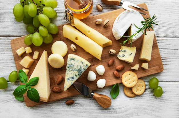 Verschiedene Arten von Käse auf einem weißen hölzernen Hintergrund