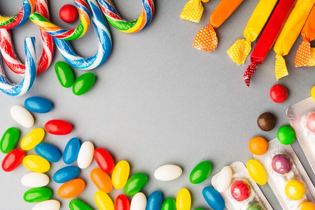 Verschiedene Arten von Süßigkeiten über grauem Hintergrund