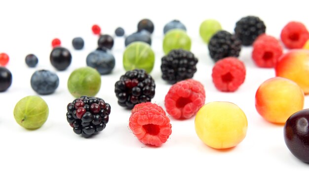 Verschiedene Beeren Nahaufnahme auf weißem Hintergrund ausgebreitet. gesundes und vitaminreiches Essen