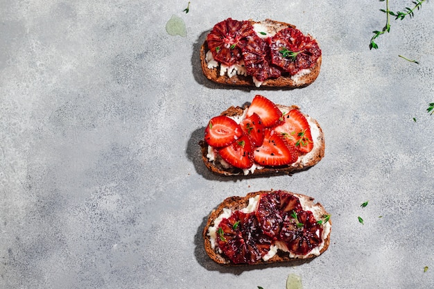 Verschiedene Bruschetta mit Vollkornbrot, Quark, Blutorange, Erdbeere, Thymian