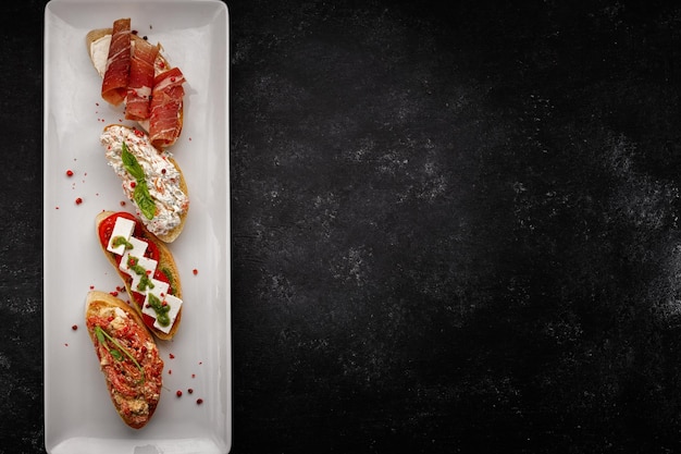 Verschiedene Bruschettas mit Schinken, Meeresfrüchten, Gemüse und Käse