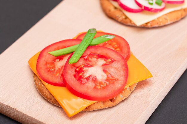 Verschiedene Cracker-Sandwiches mit Tomaten-Gurken-Rettich und Käse