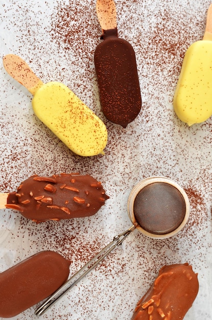 Verschiedene Eissorten am Stiel, bestreut mit Kakao