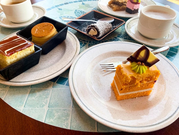 Verschiedene farbige Kuchen auf Tellern. Süße Desserts. Studiofoto