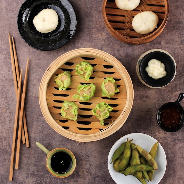 Verschiedene flache chinesische Speisen Dim Sum auf Bambus-Dampfer über Beton Brown Top legen