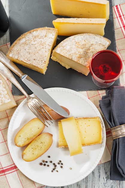 Verschiedene französische Käsesorten mit einem Glas Wein