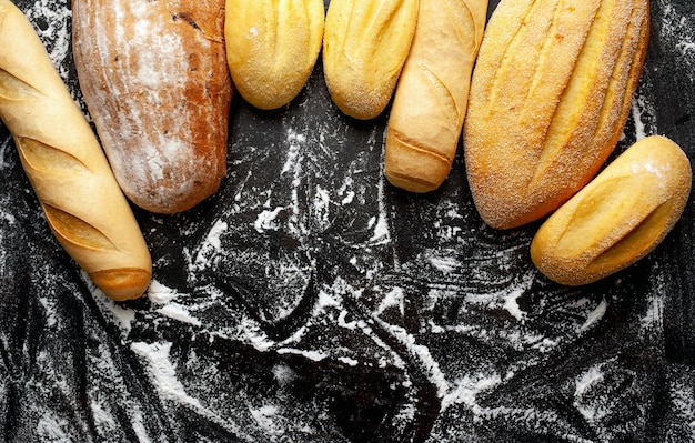 Verschiedene frische Brote und Brötchen auf einem Steintisch.