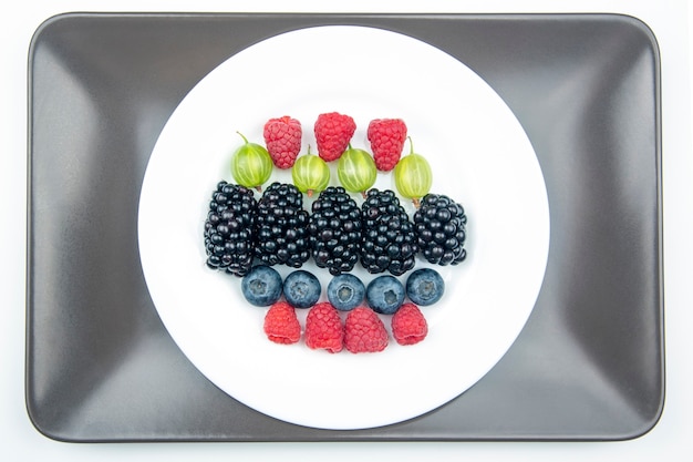 Verschiedene frische verschiedene Beeren auf einem weißen Teller. nützliches Vitamin gesundes Essen Obst. gesundes Gemüsefrühstück